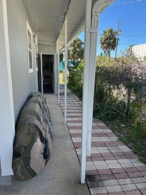 6837 Flicker Lane Hudson, FL 34667 - Photo 25 of 28 a view of a porch with a floor to ceiling window and potted plants