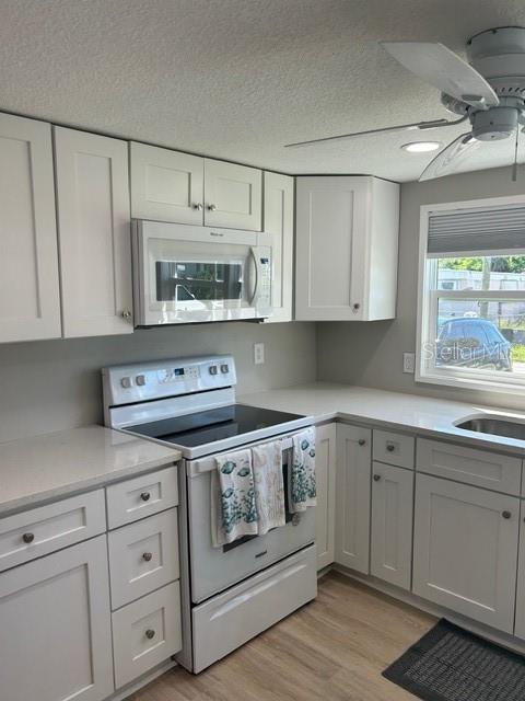 6837 Flicker Lane Hudson, FL 34667 - Photo 5 of 28 a kitchen with white cabinets and appliances