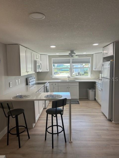 6837 Flicker Lane Hudson, FL 34667 - Photo 9 of 28 a kitchen with a table chairs refrigerator and cabinets