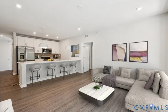 a living room with stainless steel appliances kitchen island furniture and a kitchen view