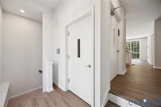 a view of a hallway with wooden floor and closet area