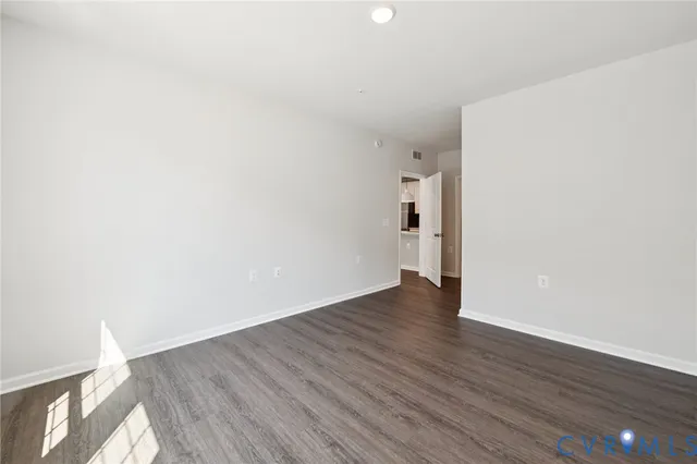 a view of an empty room with wooden floor