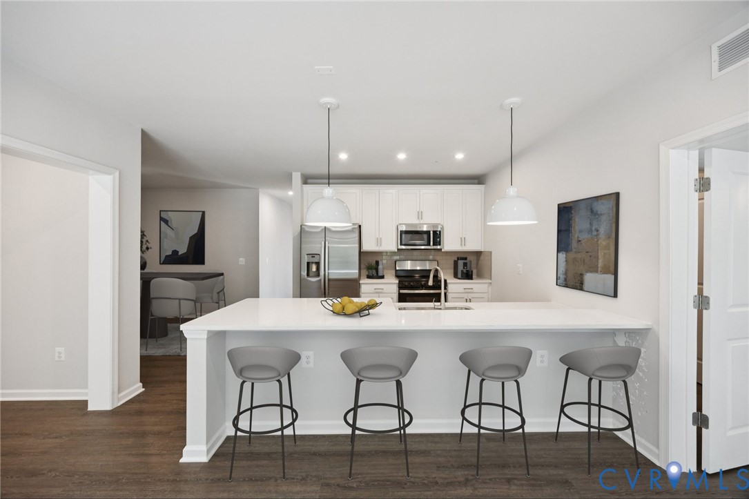 13239 Garland Lane Midlothian, VA 23114 - Photo 5 of 48 a kitchen with stainless steel appliances kitchen island granite countertop a dining table chairs and a refrigerator