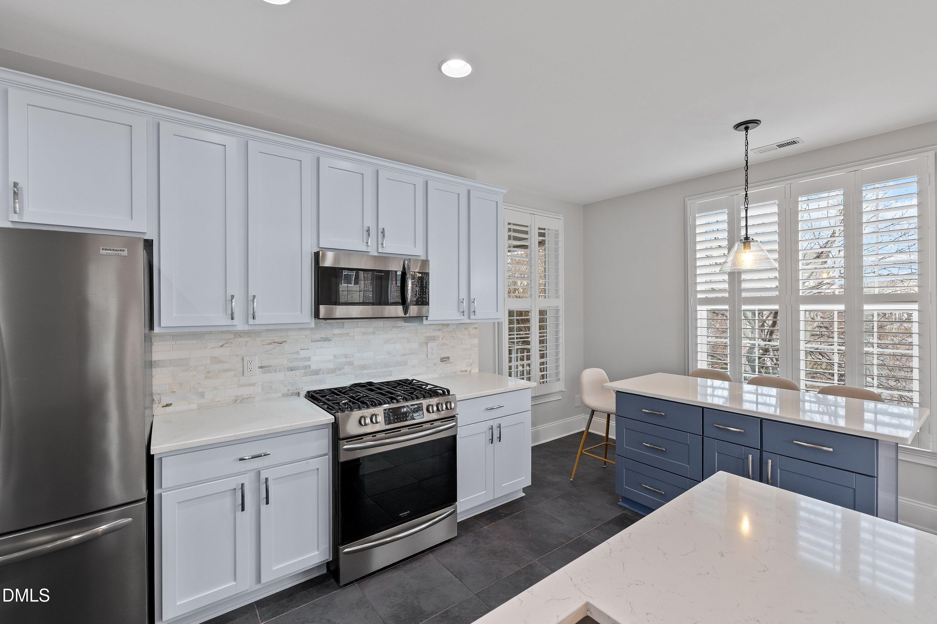 9211 Calabria Drive, Unit 205 Raleigh, NC 27617 - Photo 19 of 55 a kitchen with stainless steel appliances a stove a sink a refrigerator and cabinets