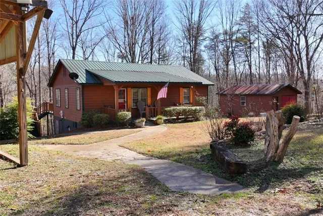 a view of a livingroom with a fireplace a ceiling fan and wooden floor