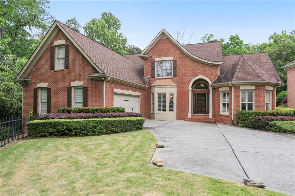 6991 Brandon Mill Road Northwest Sandy Springs, GA 30328 - Photo 1 of 1 a front view of a house with a garden
