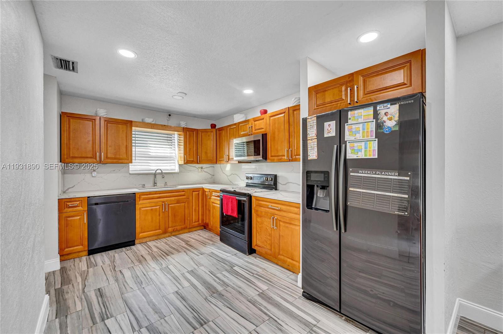 4751 Northwest 5th Court Plantation, FL 33317 - Photo 15 of 34 a large kitchen with stainless steel appliances granite countertop a stove and cabinets