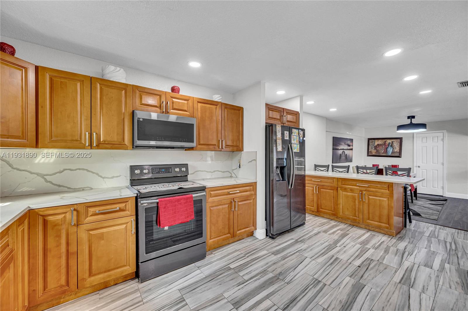 4751 Northwest 5th Court Plantation, FL 33317 - Photo 16 of 34 a kitchen with stainless steel appliances granite countertop wooden cabinets a stove top oven a sink and dishwasher with wooden floor