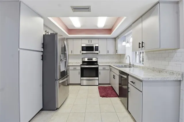 a kitchen with stainless steel appliances a refrigerator and a stove top oven