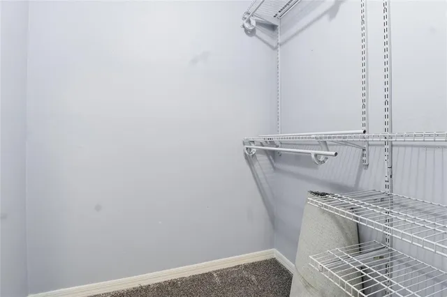 an empty room with chandelier fan and windows