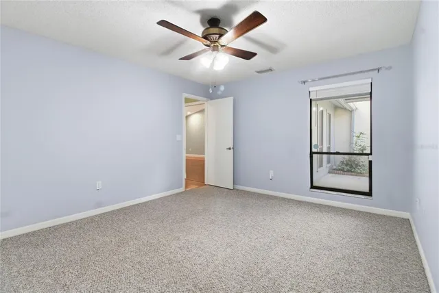 an empty room with closet and ceiling fan