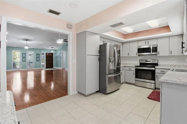 a kitchen with stainless steel appliances granite countertop a stove a sink and a refrigerator