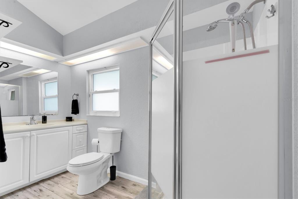 819 10th Street Southwest Largo, FL 33770 - Photo 20 of 85 a bathroom with a toilet a sink a mirror a shower a vanity and window