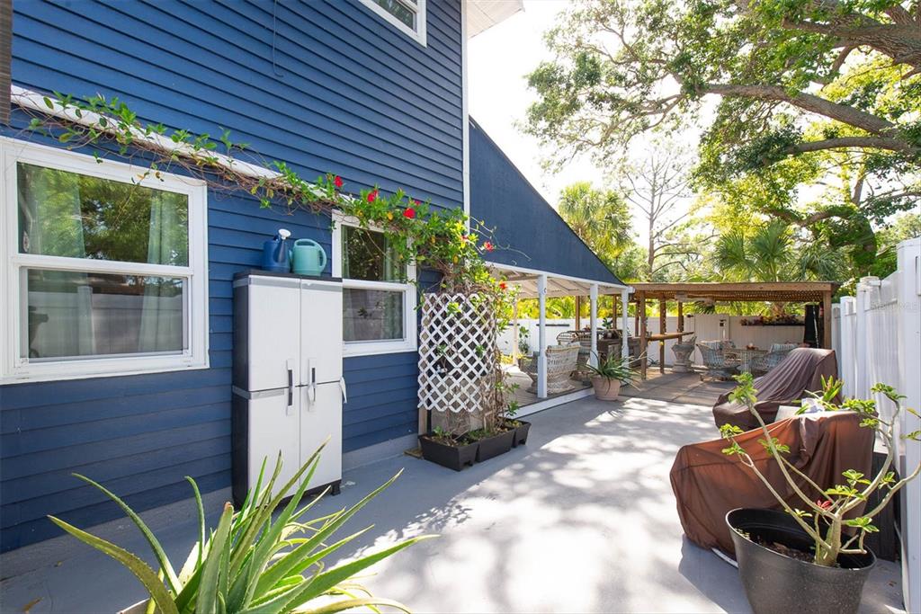 819 10th Street Southwest Largo, FL 33770 - Photo 55 of 85 a view of a patio with table and chairs with wooden fence and potted plants