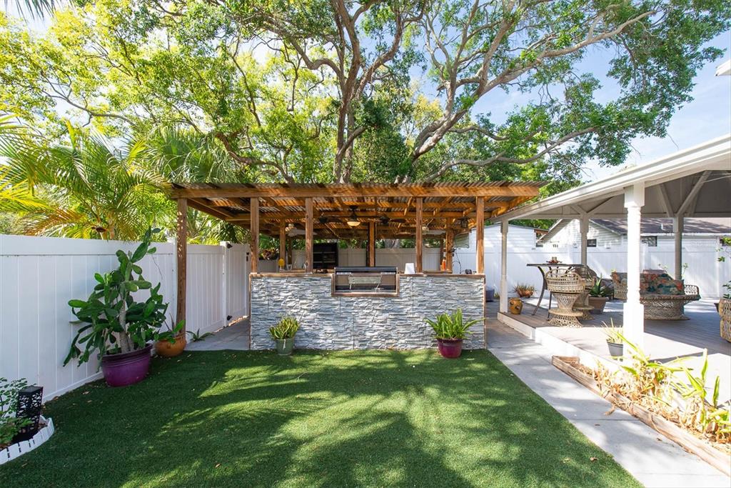 819 10th Street Southwest Largo, FL 33770 - Photo 66 of 85 a view of a patio with table and chairs potted plants and large tree