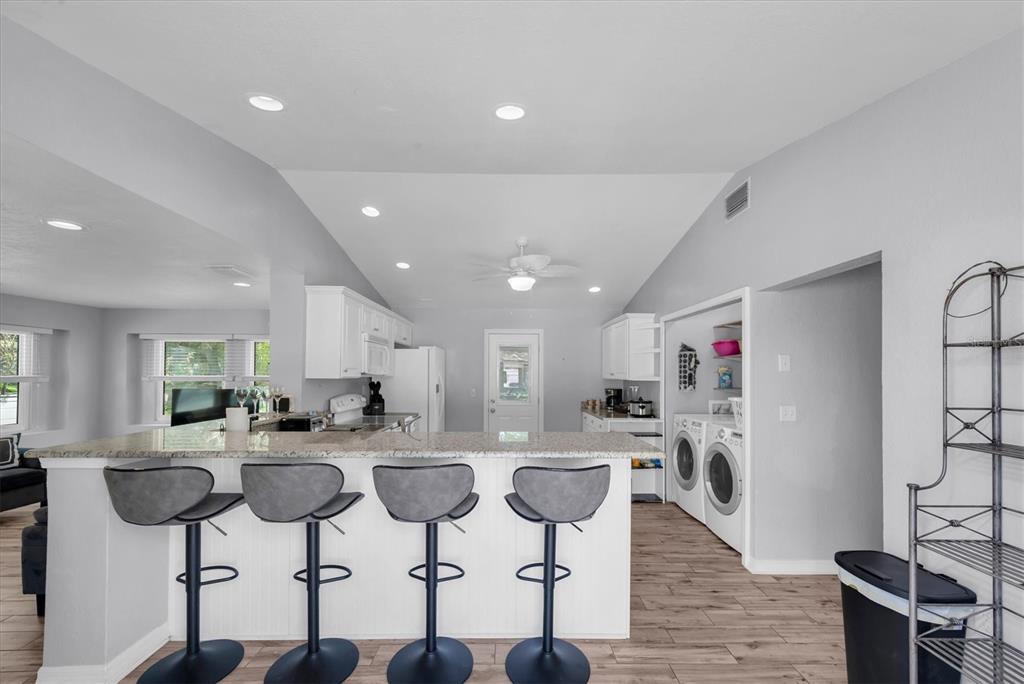 819 10th Street Southwest Largo, FL 33770 - Photo 8 of 85 a kitchen with stainless steel appliances kitchen island granite countertop a stove a refrigerator a sink and white cabinets with wooden floor