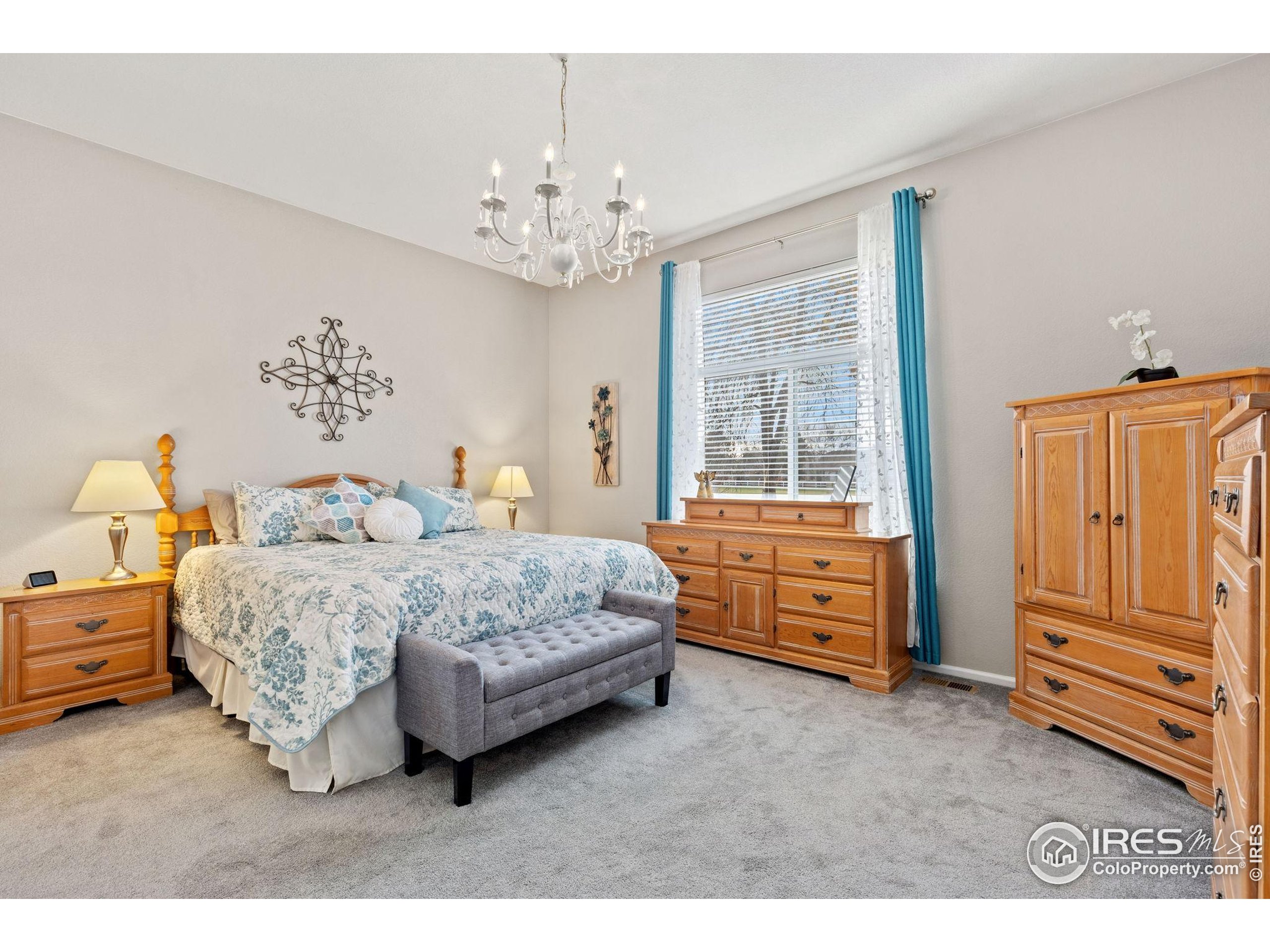 10166 Scenic Court Firestone, CO 80504 - Photo 15 of 33 a bedroom with a bed and a chandelier