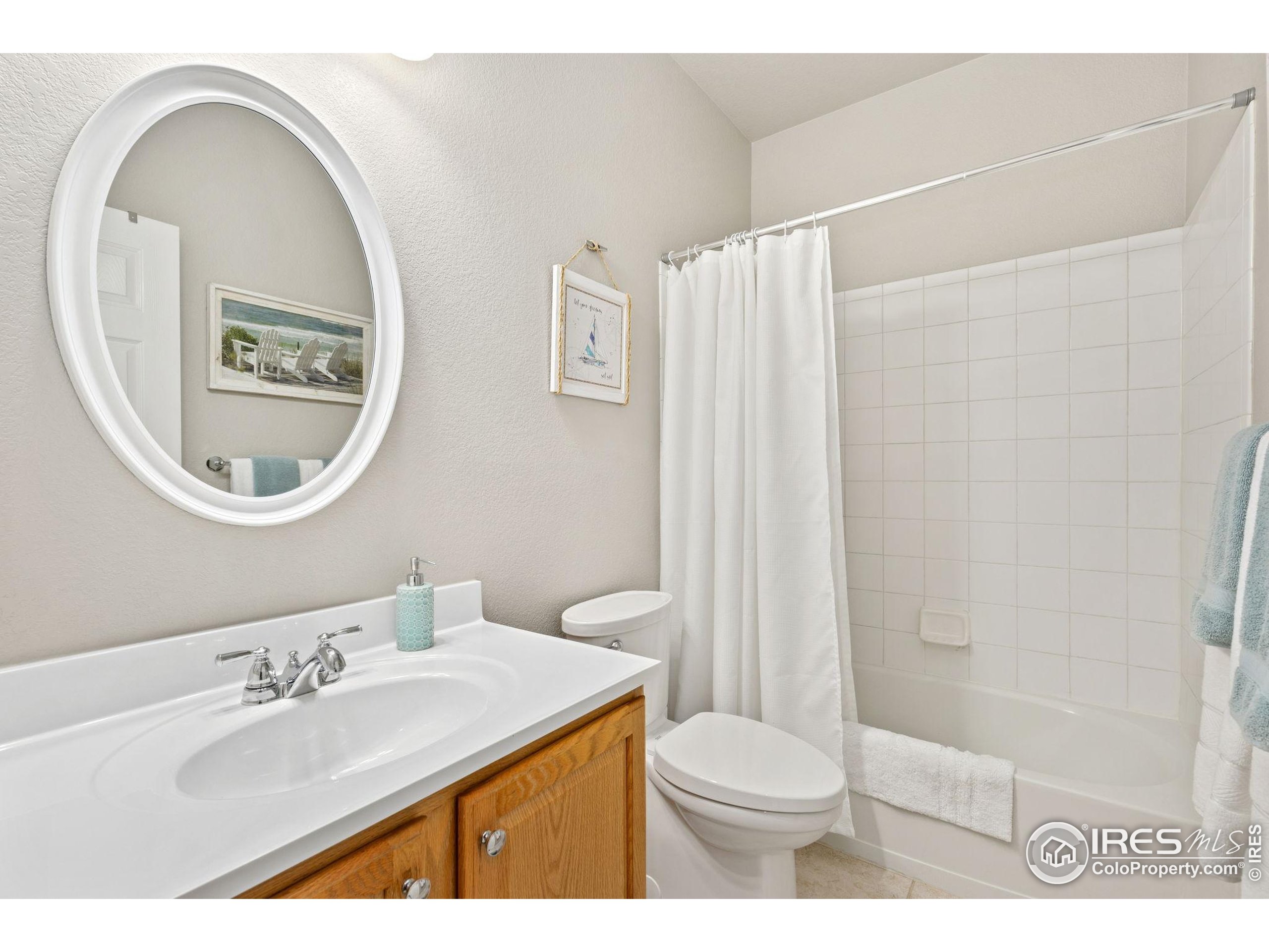 10166 Scenic Court Firestone, CO 80504 - Photo 20 of 33 a bathroom with a sink a mirror a toilet and a shower