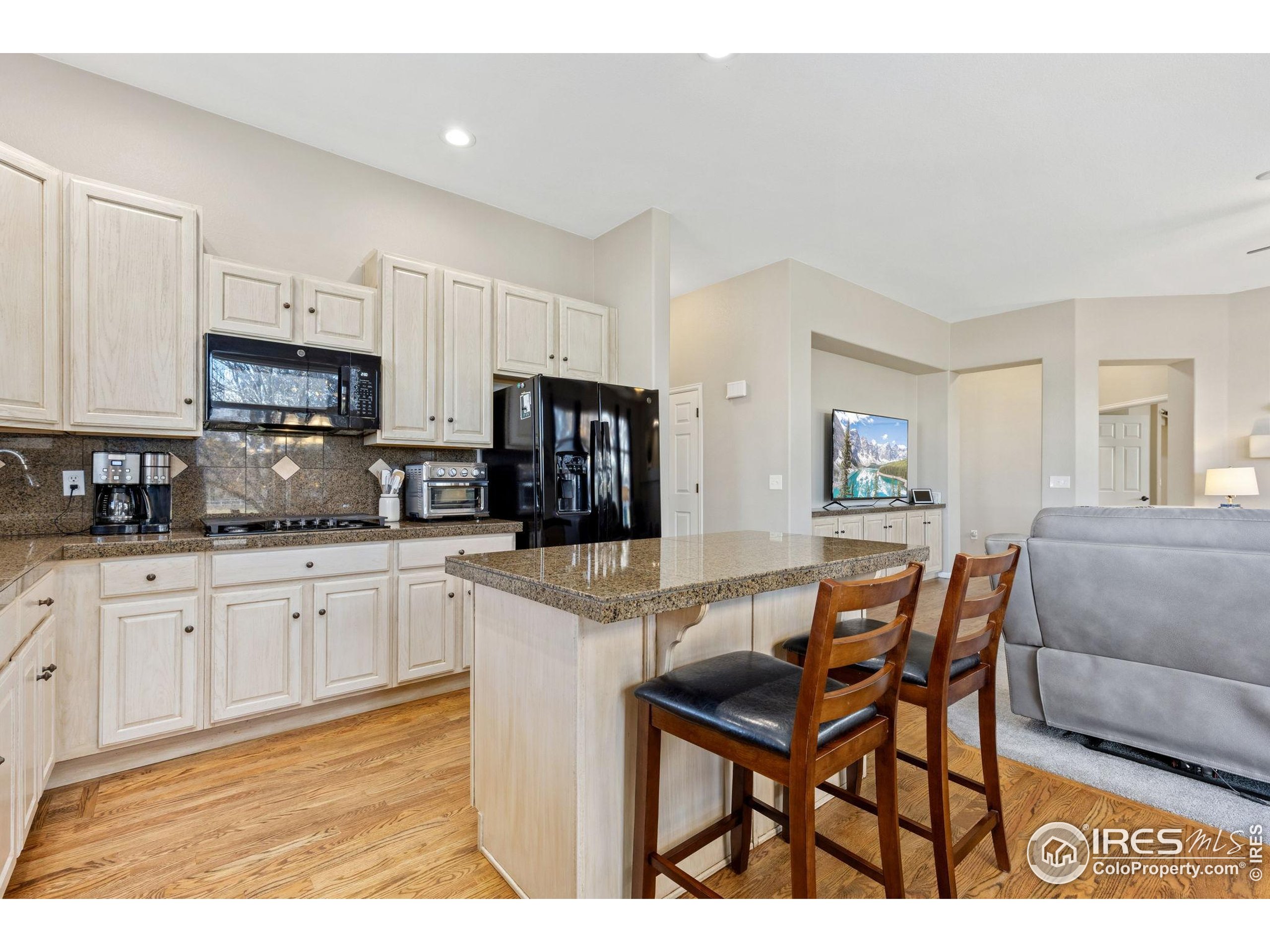 10166 Scenic Court Firestone, CO 80504 - Photo 9 of 33 a kitchen with stainless steel appliances granite countertop a stove a sink a microwave a dining table and chairs