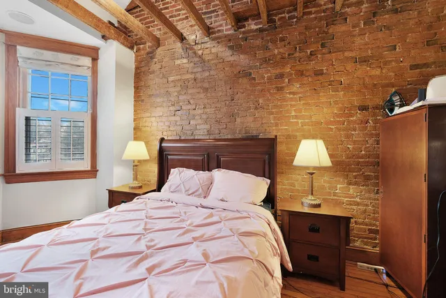 a bedroom with a bed and a lamp on dresser