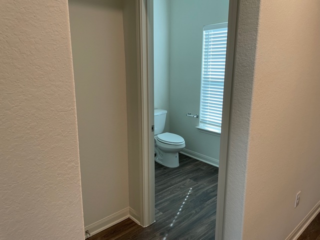 18812 Speculator Lane Elgin, TX 78621 - Photo 11 of 24 Half bath featuring a textured wall and dark wood-style floors