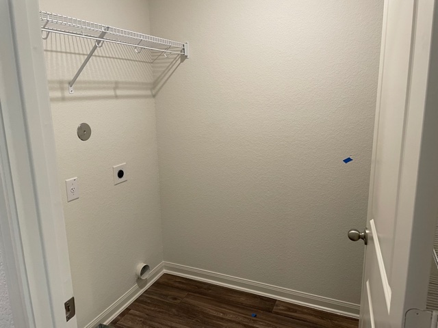18812 Speculator Lane Elgin, TX 78621 - Photo 13 of 24 Laundry room with electric dryer hookup, dark wood-style floors, and a textured wall