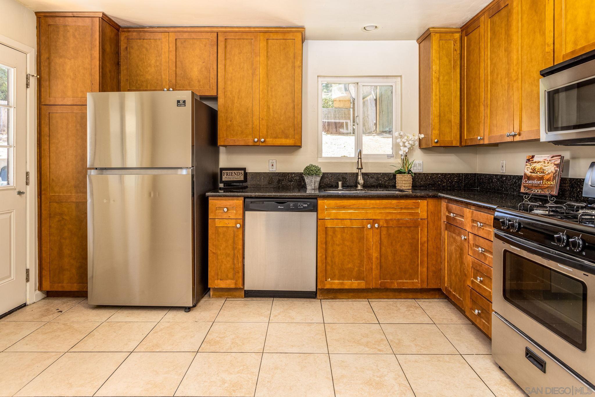6643 San Miguel Lemon Grove, CA 91945 - Photo 23 of 34 a kitchen with stainless steel appliances granite countertop a refrigerator sink and stove