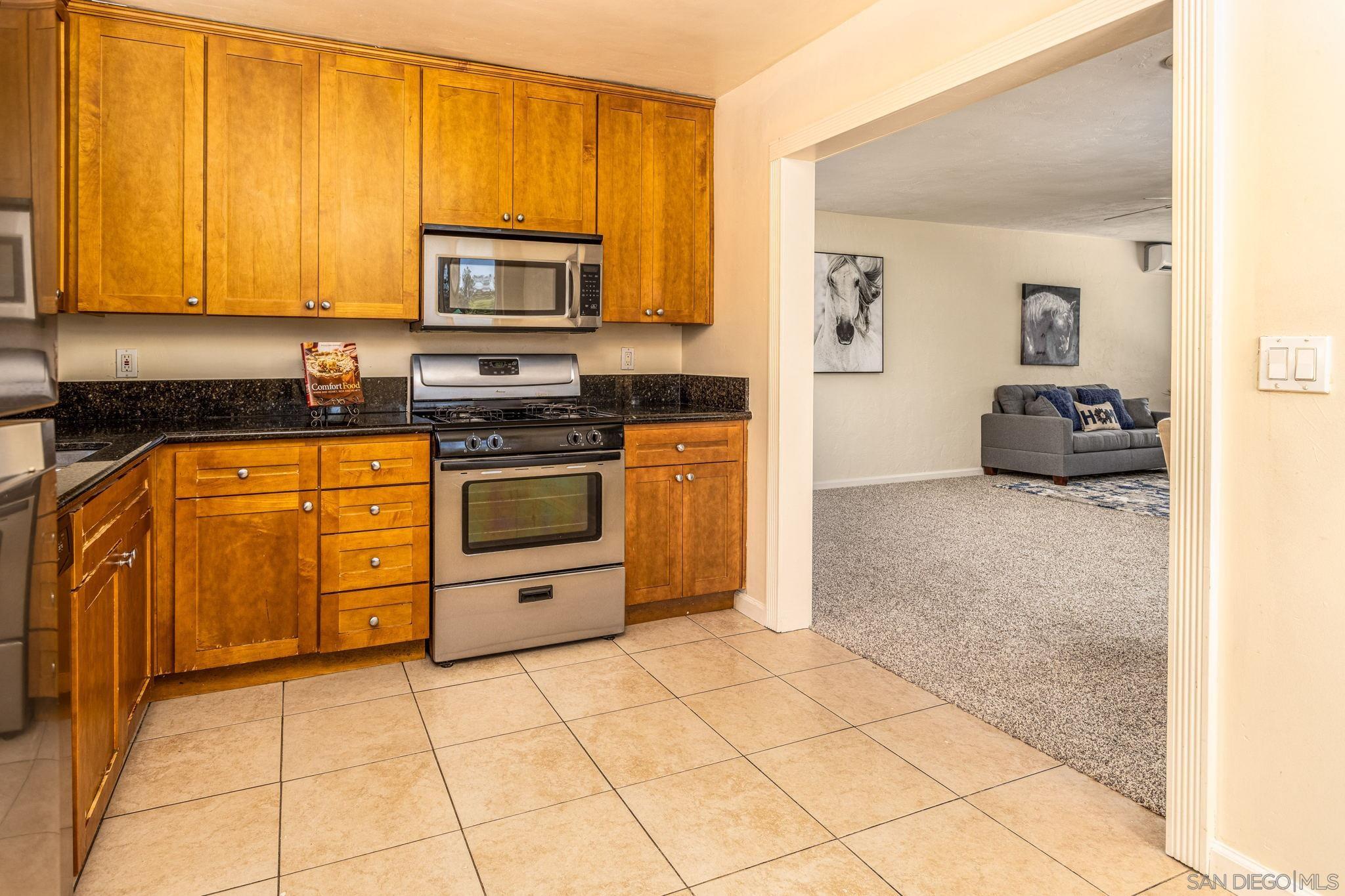 6643 San Miguel Lemon Grove, CA 91945 - Photo 26 of 34 a kitchen with stainless steel appliances granite countertop a stove a sink and a microwave