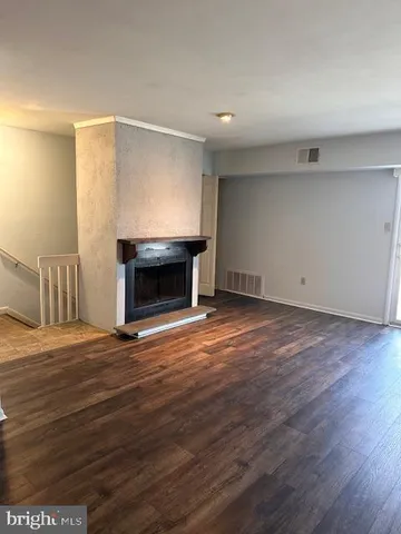 a view of empty room with wooden floor and fireplace