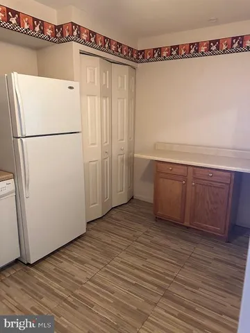 a view of a refrigerator with wooden floor