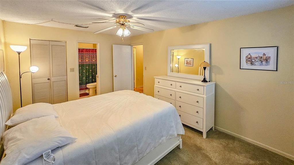 5660 80th Street North, Unit A303 St. Petersburg, FL 33709 - Photo 17 of 72 a bedroom with a bed and a chandelier