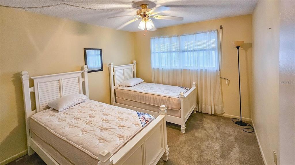 5660 80th Street North, Unit A303 St. Petersburg, FL 33709 - Photo 20 of 72 a bedroom with a bed and a chandelier
