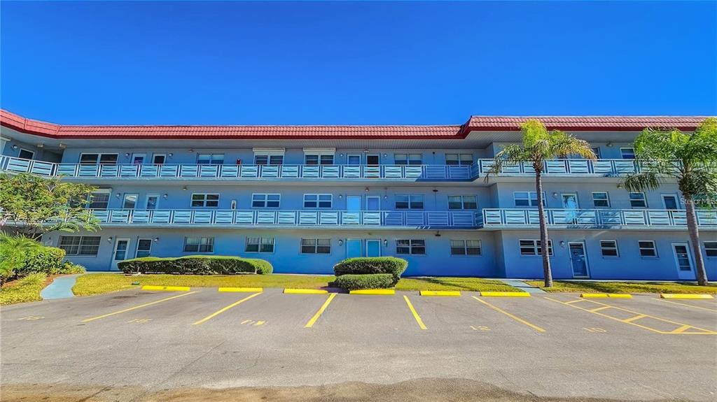 5660 80th Street North, Unit A303 St. Petersburg, FL 33709 - Photo 2 of 72 a view of a swimming pool with a lawn chairs under an umbrella