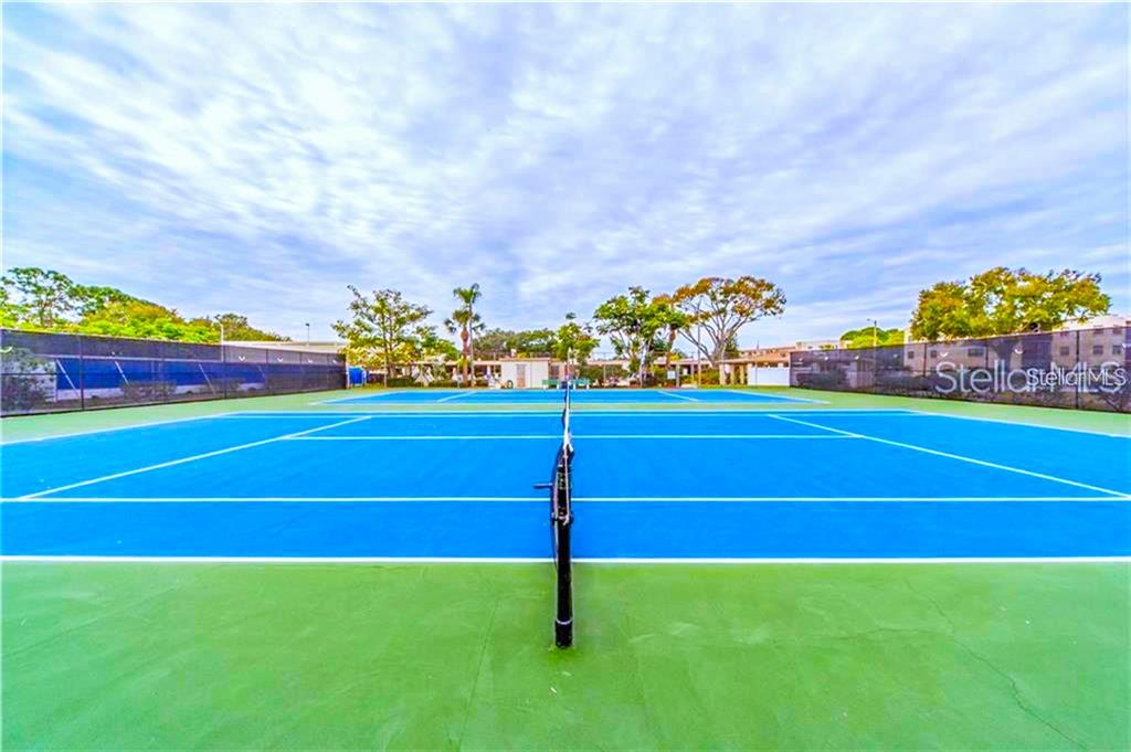 5660 80th Street North, Unit A303 St. Petersburg, FL 33709 - Photo 63 of 72 a view of an outdoor space and tennis court