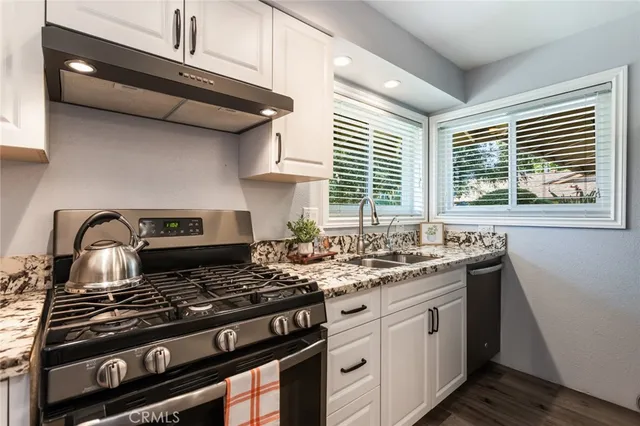 a kitchen with granite countertop a refrigerator and a stove