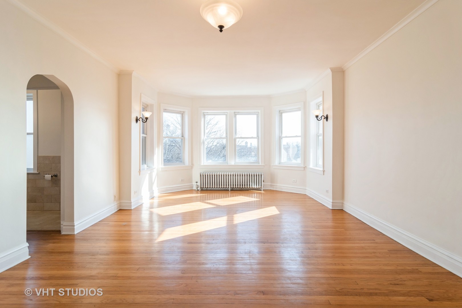 2901 West Arthur Avenue, Unit 3 Chicago, IL 60645 - Photo 3 of 13 a view of an empty room with window and wooden floor