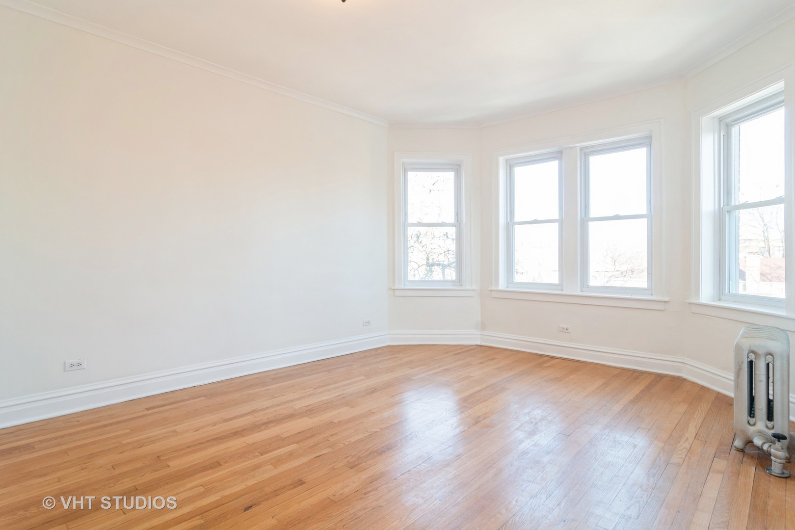 2901 West Arthur Avenue, Unit 3 Chicago, IL 60645 - Photo 6 of 13 an empty room with wooden floor and windows