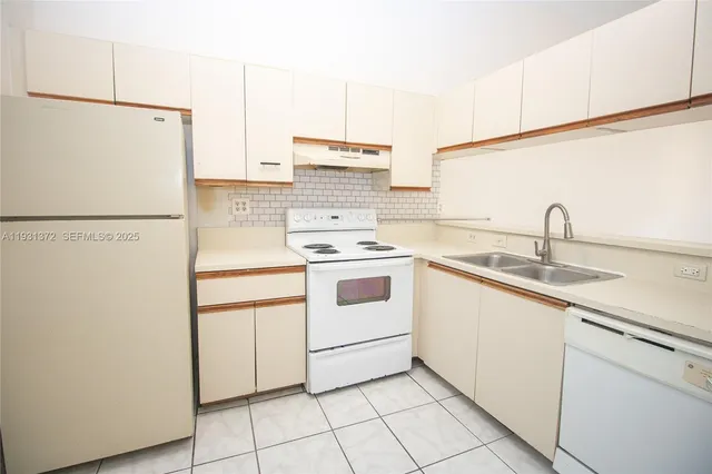 a kitchen with white cabinets and white appliances