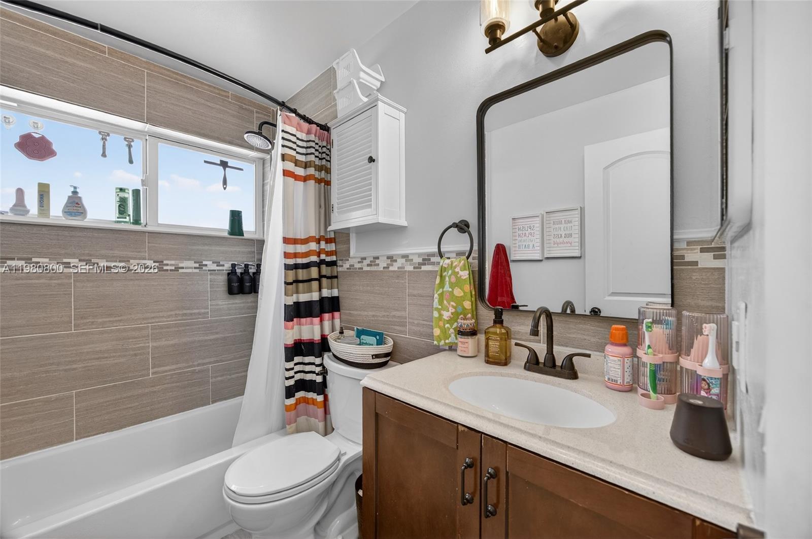 15260 Southwest 57th Street Miami, FL 33193 - Photo 15 of 22 a bathroom with a sink vanity mirror bathtub and toilet