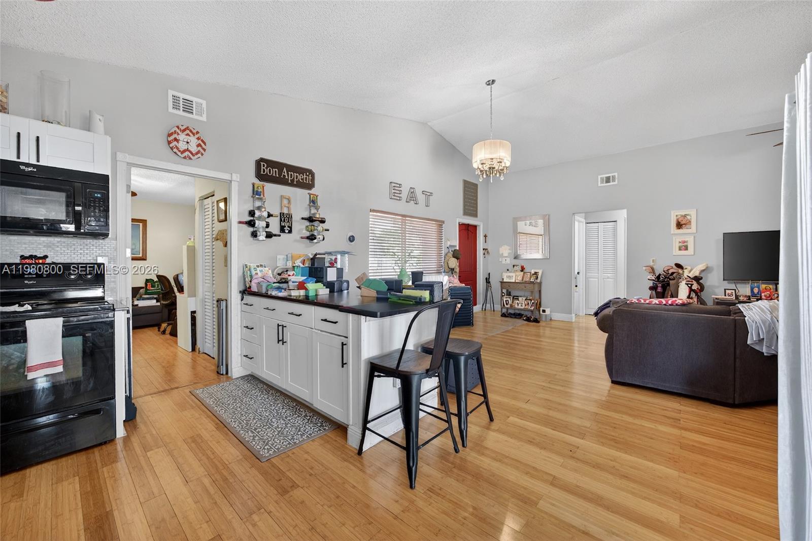 15260 Southwest 57th Street Miami, FL 33193 - Photo 8 of 22 a kitchen with stainless steel appliances granite countertop a refrigerator oven a stove top oven a sink dishwasher and white cabinets with wooden floor