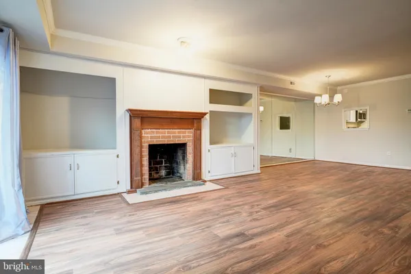 a view of a livingroom with wooden floor and a fireplace