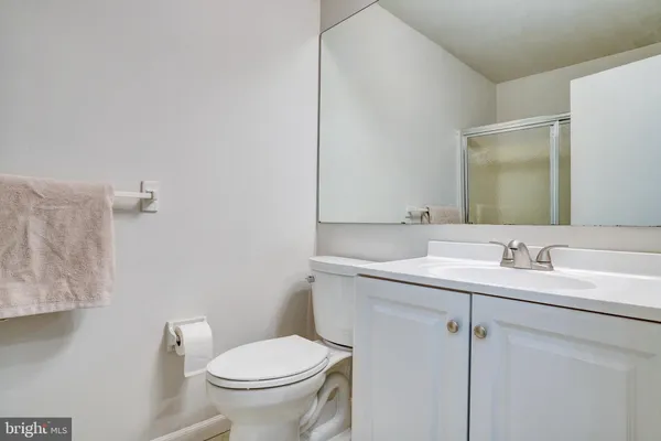 a bathroom with a granite countertop toilet sink and mirror