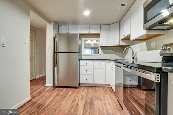 a kitchen with a refrigerator sink and cabinets