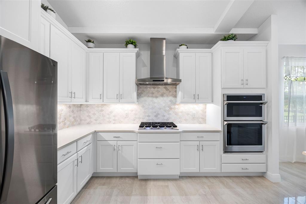 12739 Rainwashed Loop Parrish, FL 34219 - Photo 14 of 45 a kitchen with white cabinets and stainless steel appliances