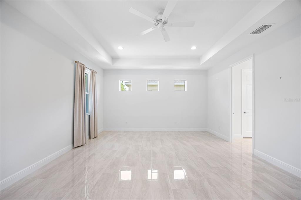 12739 Rainwashed Loop Parrish, FL 34219 - Photo 23 of 45 an empty room with a ceiling fan and windows