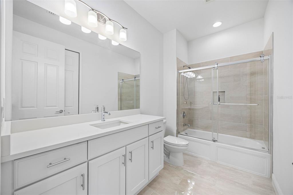 12739 Rainwashed Loop Parrish, FL 34219 - Photo 28 of 45 a bathroom with a double vanity sink toilet mirror and shower