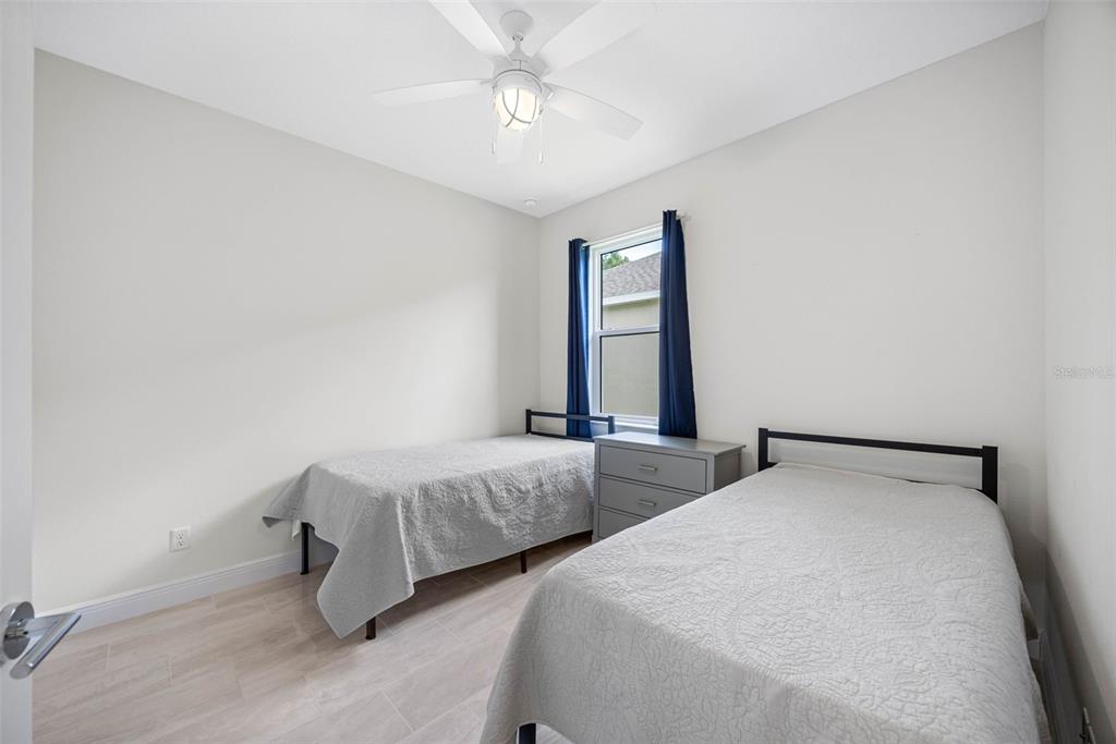 12739 Rainwashed Loop Parrish, FL 34219 - Photo 29 of 45 a bedroom with two beds and a chandelier