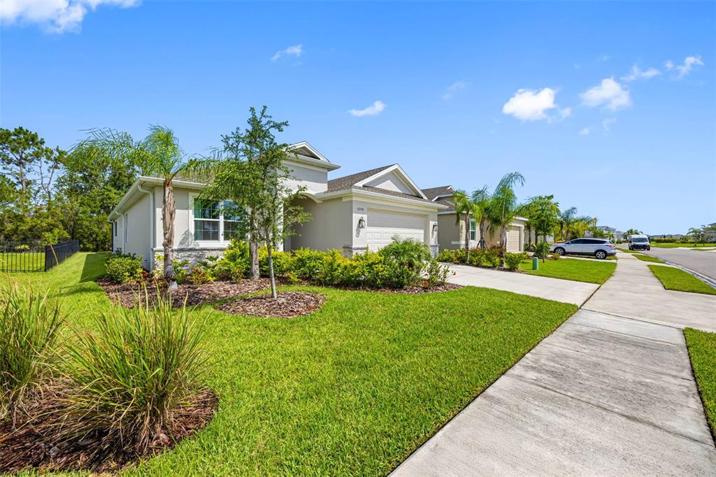 12739 Rainwashed Loop Parrish, FL 34219 - Photo 3 of 45 a front view of a house with a yard and potted plants