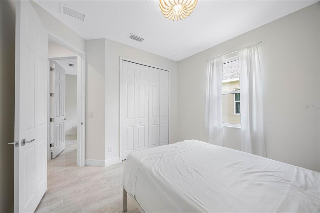 12739 Rainwashed Loop Parrish, FL 34219 - Photo 32 of 45 a bedroom with a bed and a painting on the wall