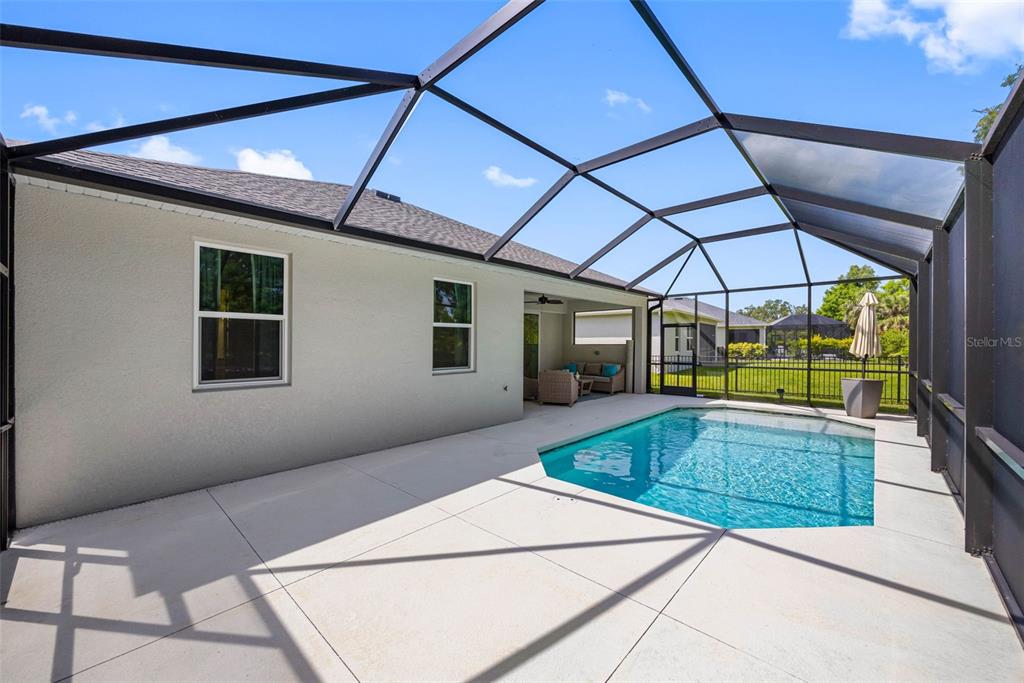 12739 Rainwashed Loop Parrish, FL 34219 - Photo 36 of 45 a view of a patio with a table and chairs under an umbrella
